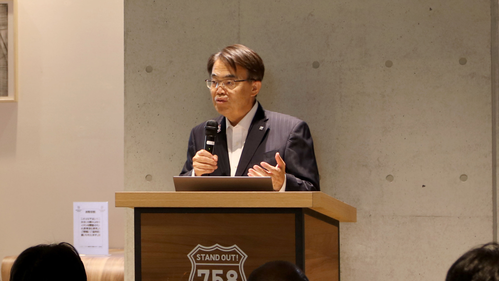 演台から参加者に語りかける来賓の愛知県知事 大村秀章氏
