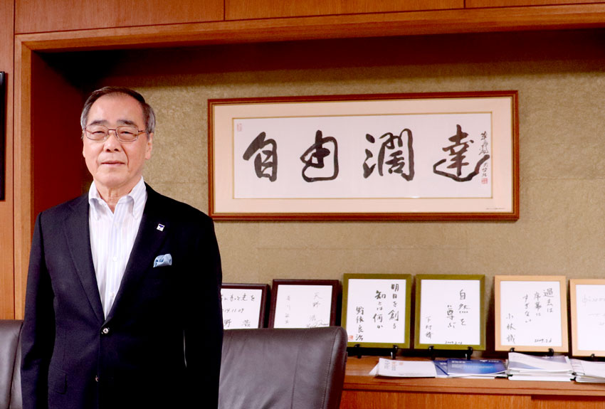 名古屋大学の学風「自由闊達」が書かれた書の額を背景にした松尾東海国立大学機構 機構長の画像